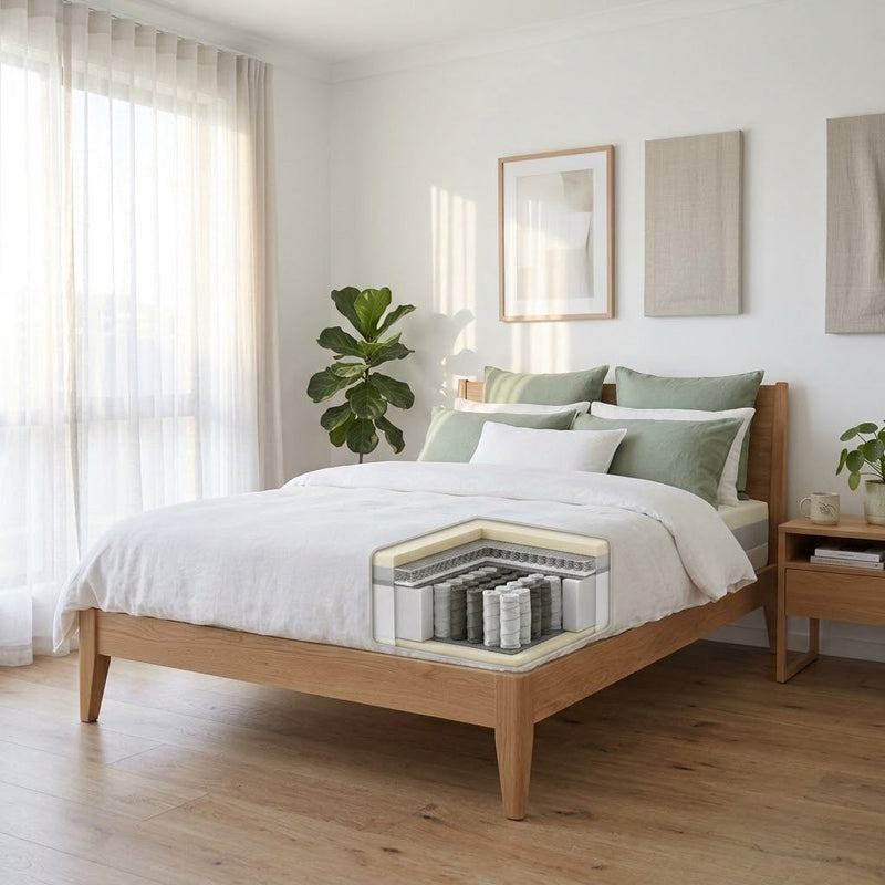 Medium-firm hybrid mattress with a low flat pillow in an Australian bedroom, zoned pocket springs visible at the corner — best mattress for stomach and combination sleepers