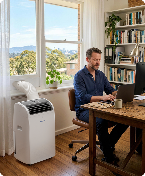 Man working at a desk in a home office with a Newentor portable air conditioner