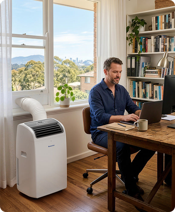 Man working at a desk in a home office with a Newentor portable air conditioner